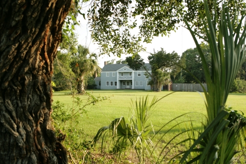 Dominick House at the back of the front lawn, is set among palmetto and live oak trees 