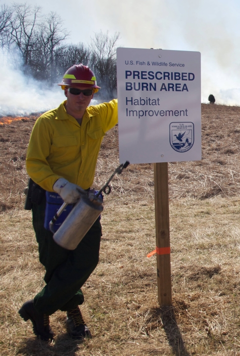 Male firefighter with drip torch