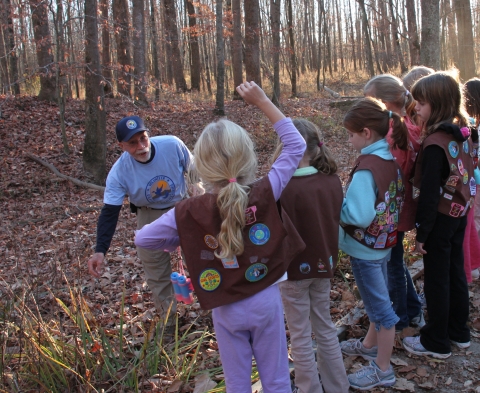 Refuge volunteer showing plants to Girl Scout group
