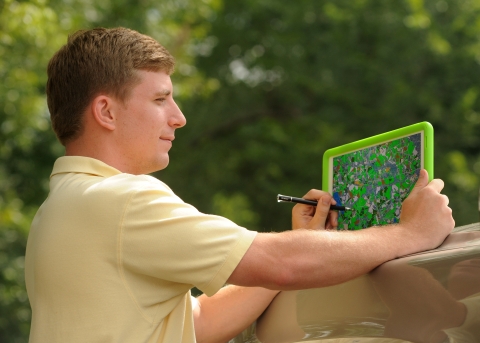 Young man holds tablet computer showing survey map