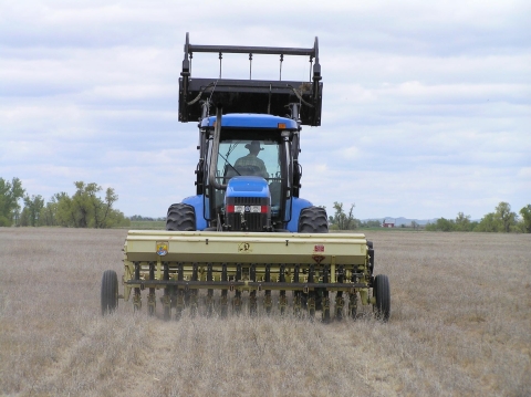 Large farming equipment driving through field
