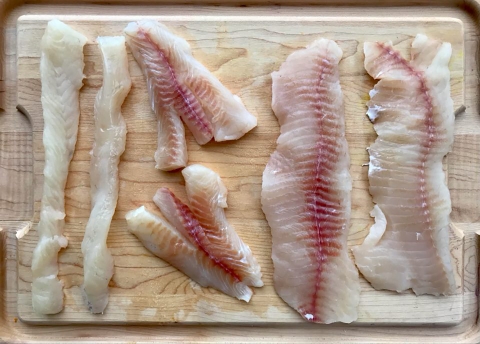 fillets of fish on a wood cutting board