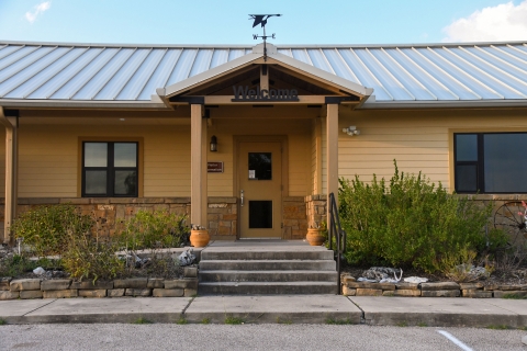 A brown building with the word "Welcome" over the door