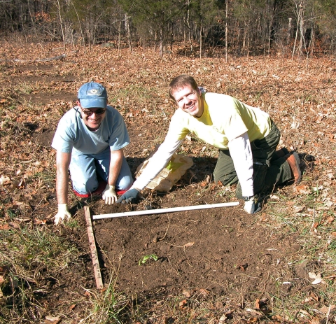 Two men working to preparing soil to plant seeds