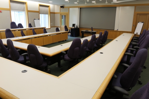classroom with tables set up as a u-shape with black chairs