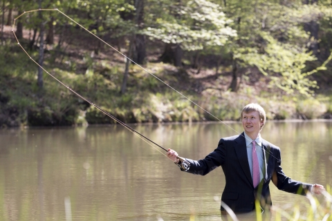 man fly fishing in a suit