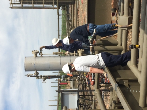 Three oil and gas workers working on a rig