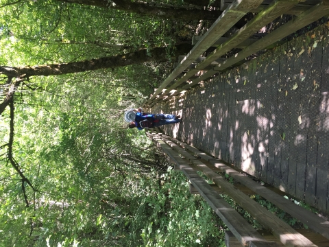 A volunteer carries tools and supplies down the Rail Trail boardwalk