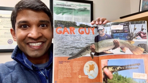 man holding a magazine with words "Gar Guy"