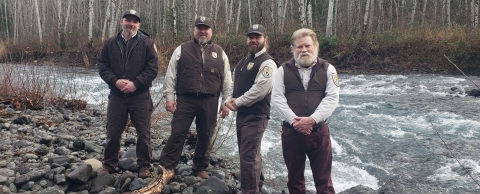 Quilcene National Fish Hatchery staff next to the Big Quilcene River