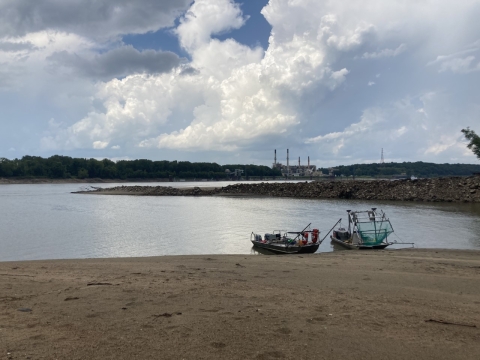 An electrofishing boat and an electrified dozer trawl boat are pulled up on shore on the Mississippi River