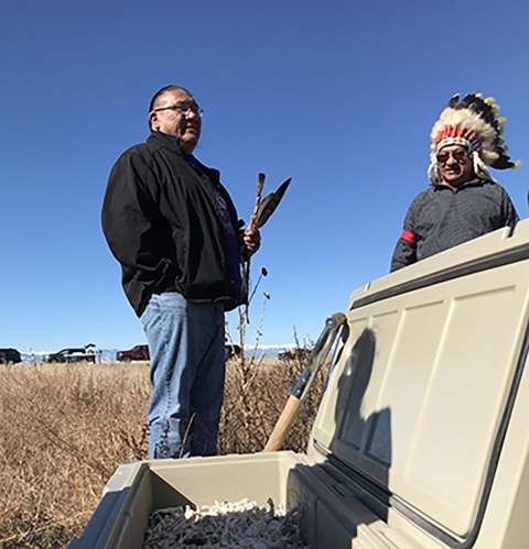 Oglala Lakota and Southern Ute Tribe leader stand over a container of eagle remains.