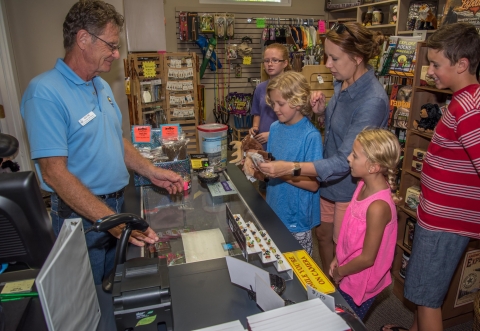 volunteer Wayne Allan helps visitors in Friends shop