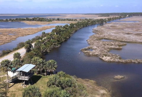 An aerial view of coastal wetlands with viewing platform in the foreground