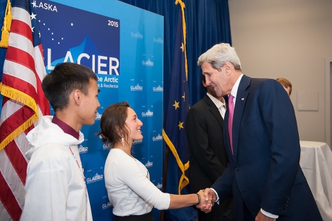 a young man and woman meet an older man at an event