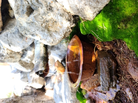 A small pipe drains spring water into a copper pan