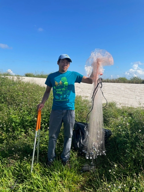 A National Public Lands Day cleanup volunteer stands with a cast net.