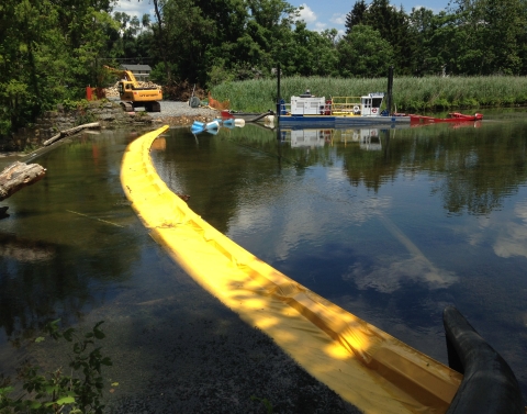 pond with yellow strip through it, and work equipment at pond's eedge