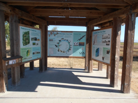 photo of 3 kiosk panels (not readable) and brochure holder on the far left