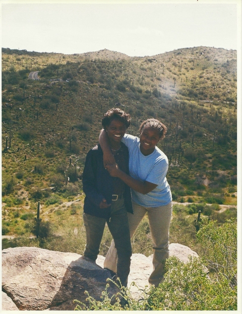 two women standing on a hill outdoors