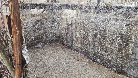 interior of hunt blind showing fastgrass covering blind and gravel inside blind