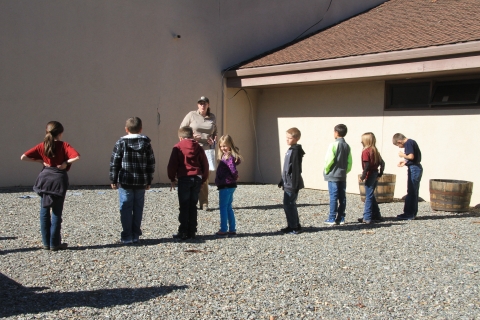 group of 8 kids standing in a row with ranger giving instructions