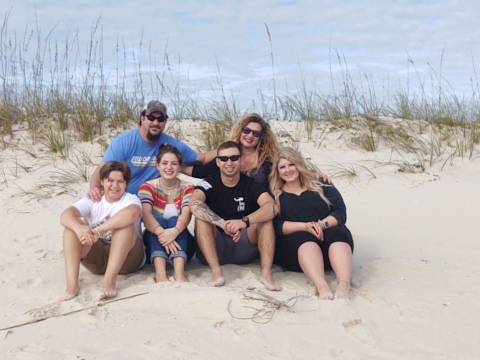 Ronald and Carrie King with family sitting in front of a sand dune