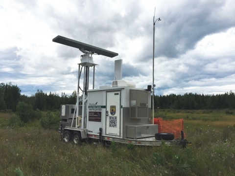 An Avian Radar unit with attached acoustic monitor in a field to monitor birds and bats.