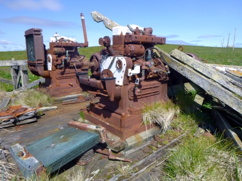 The rusted remains of two engine generators in a field.