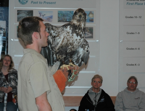 DNR naturalist holding bald eagle during program in Visitor Center