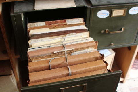 Bundled files in an old filing cabinet.