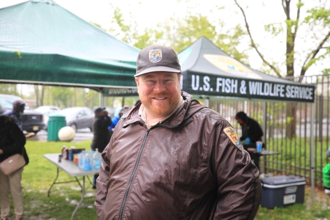 a man in U.S. Fish and Wildlife Service uniform smiles at the camera at a Service event.