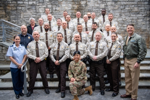 30 people in uniform pose for a group photo