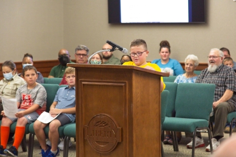 A child reads at a podium