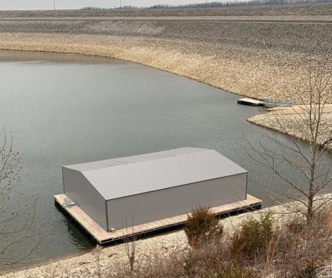 Gray metal building on a dock in a body of water