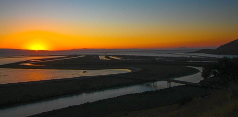 Sunset over a meandering slough and marsh. 