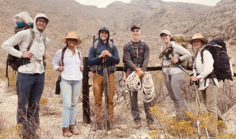 group of researchers in front of mountains