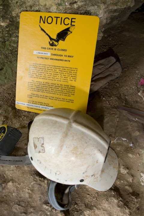 Sign and hardhat in cave entrance