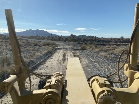 View of a dirt road from inside a piece of heavy equipment