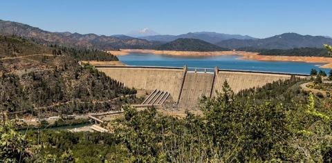 Lake and mountain in foreground of a dam.