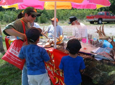 Mother and kids looking at display of deer antlers.