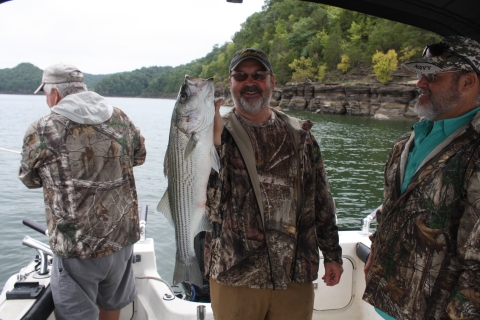 Wounded Warrior Fishing Derby participant holding striper