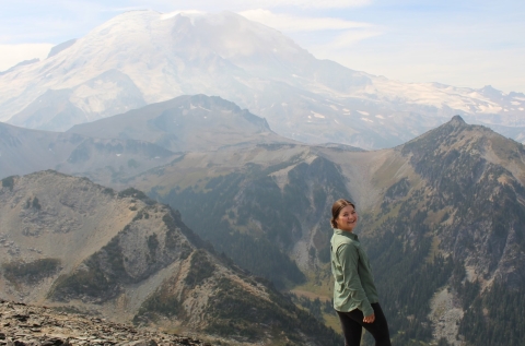 Service intern, Hannah Ferwerda, on a trail in Washington State with mountains in the background