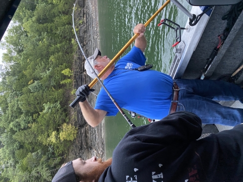 Wounded Warrior Fishing Derby participant reeling in a striper