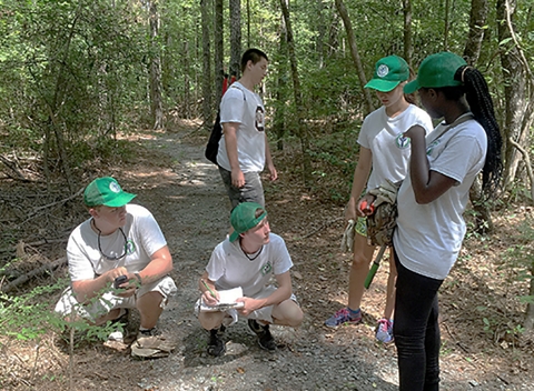 Five of the Youth Conservation Corps on a trail thinking of planning ideas