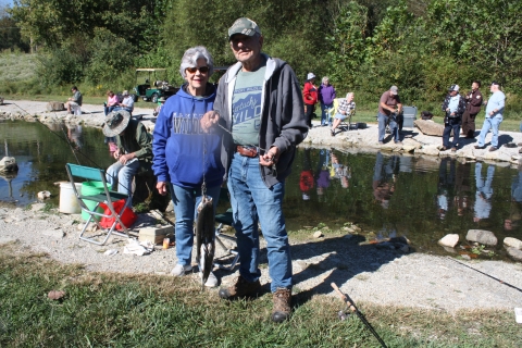 Senior couple smiling with a stringer full of Rainbow trout