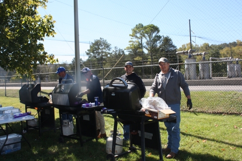 Volunteers grilling food for hatchery event.
