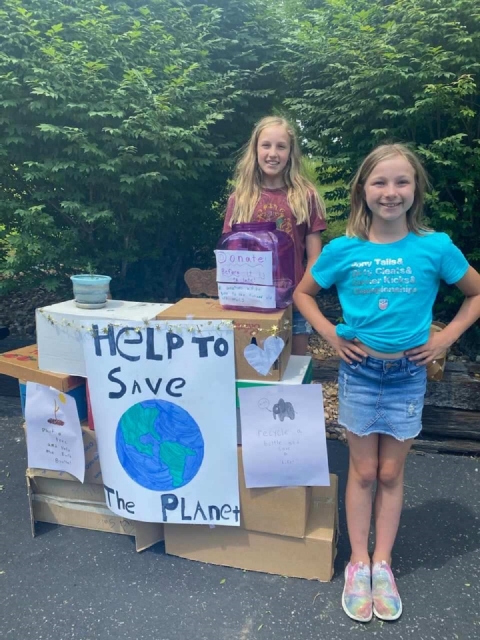 Two young ladies collecting money for a cause 