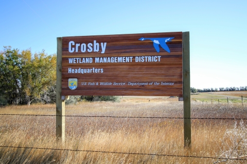 Wooden sign for Crosby Wetland Management District Headquarters.