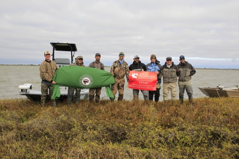 Members of the Backcountry Hunters & Anglers and the CCA posing for a picture on the shoreline in the San Bernard Wildlife Refuge 